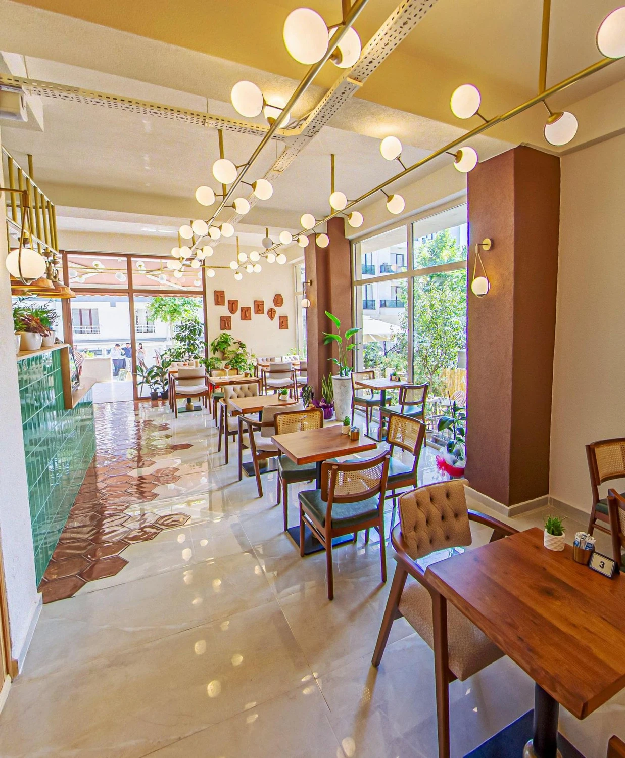 Adagan Kafe iç mekânı, doğal ışık alan ferah bir ortam ve ahşap masa sandalyeler