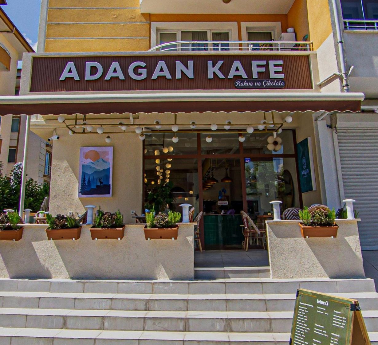 Adagan Kafe’nin dış cephesi, geniş giriş alanı ve cephe tabelasıyla ferah bir karşılama sunuyor.